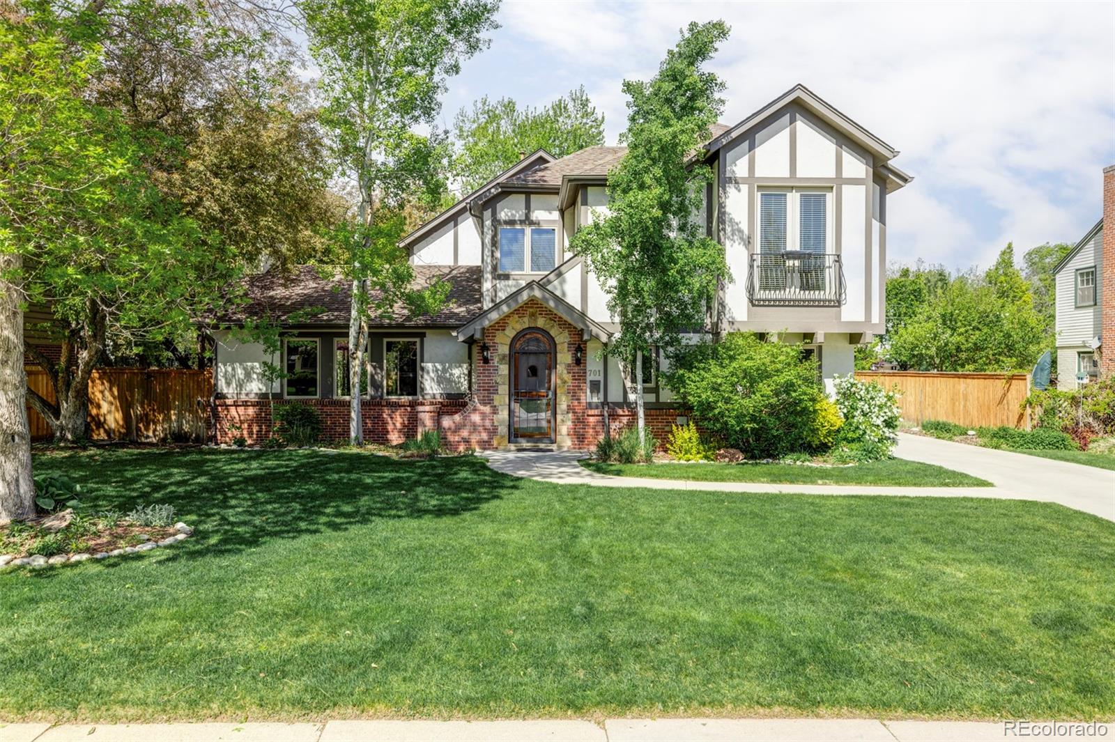 a front view of a house with a yard and trees
