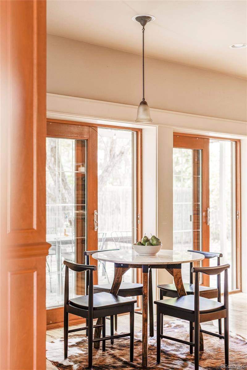 701 Leyden Street Denver, CO 80220 - Photo 20 of 42 a view of a dining room with furniture large windows and wooden floor