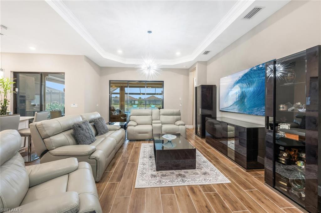 8416 Rosa Court Naples, FL 34114 - Photo 5 of 34 Open concept living area featuring wood-finish flooring and a tray ceiling