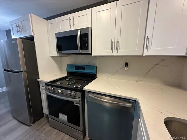 a kitchen with stainless steel appliances a stove a microwave and a refrigerator