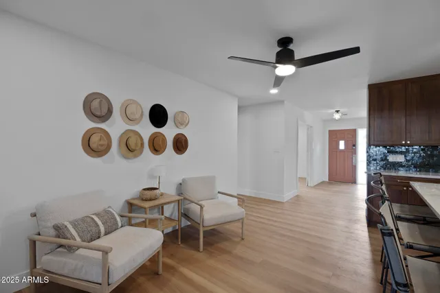 a living room with couches and kitchen view with wooden floor