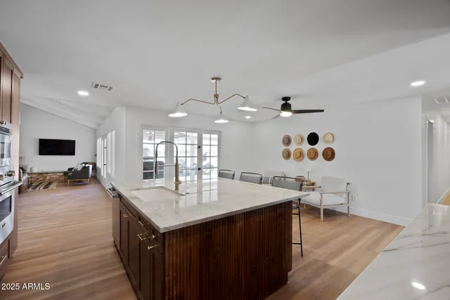 a kitchen with a sink appliances and wooden floor