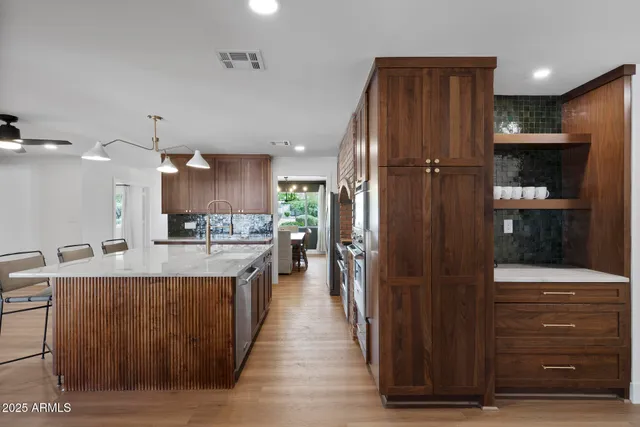 a large kitchen with kitchen island a stove a refrigerator a sink and dishwasher with wooden floor