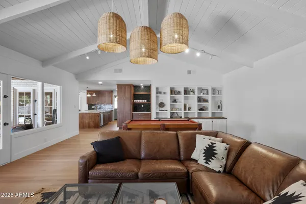 a living room with furniture kitchen view and a chandelier