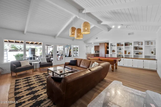 a living room with furniture kitchen view and a large window