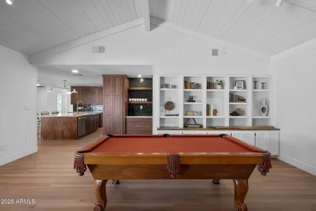 a room with pool table and windows