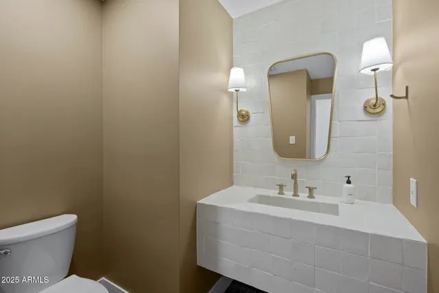 a bathroom with a toilet sink and mirror