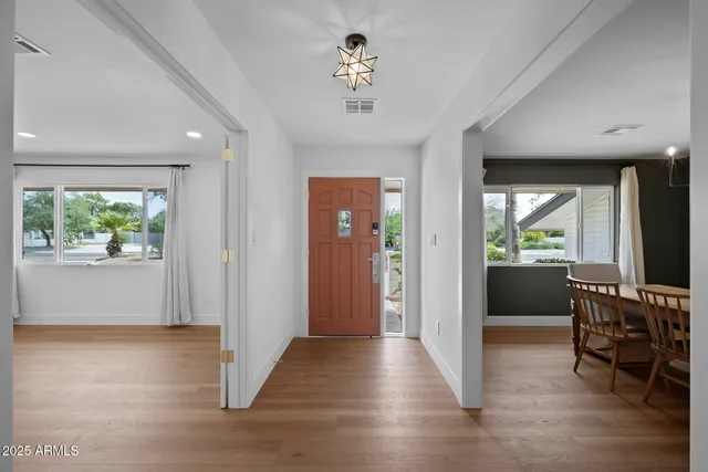 a view of a livingroom with furniture hardwood floor and windows