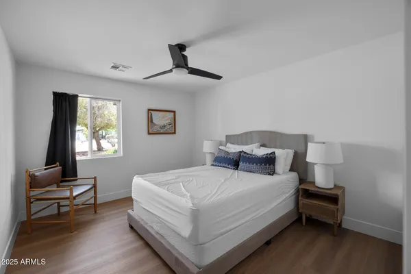 a bedroom with a bed wooden floor and a desk