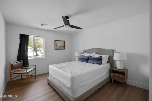 a bedroom with a bed wooden floor and a desk