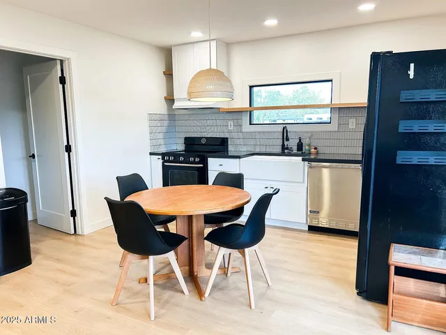 a kitchen with a table chairs sink and cabinets