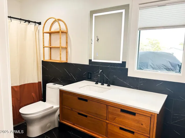 a bathroom with a sink a toilet and a window