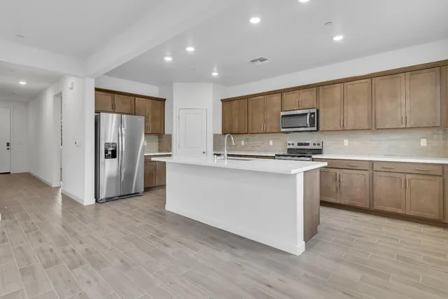 a kitchen with stainless steel appliances a refrigerator stove microwave and cabinets