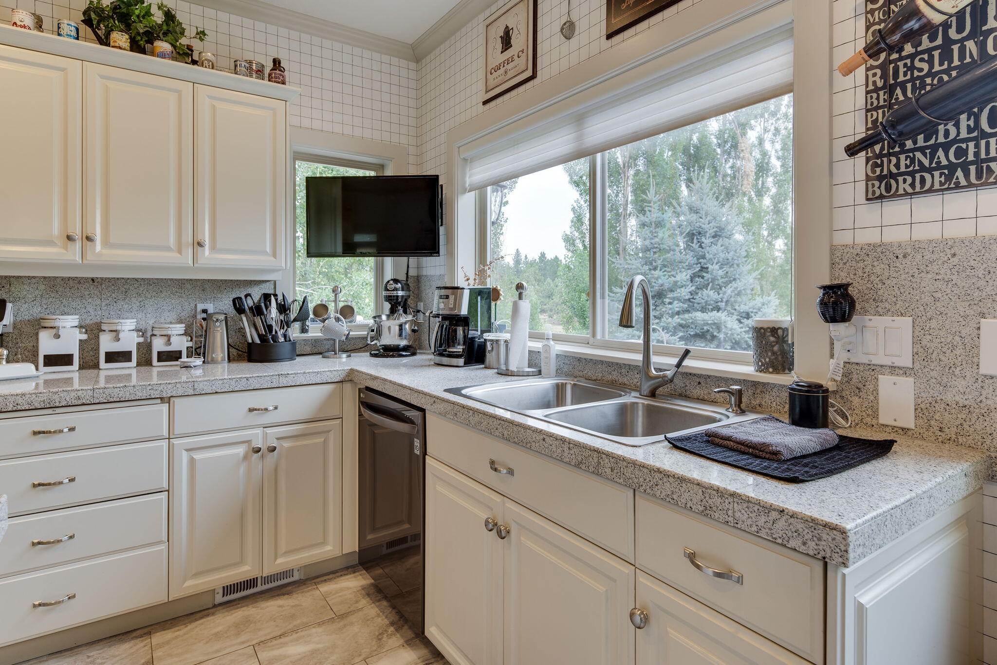 61538 Southeast Hill Ridge Road Bend, OR 97702 - Photo 18 of 59 a kitchen with white cabinets and a sink