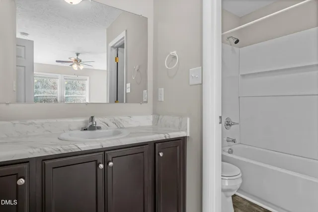 a white bath tub sitting next to a white toilet and a sink