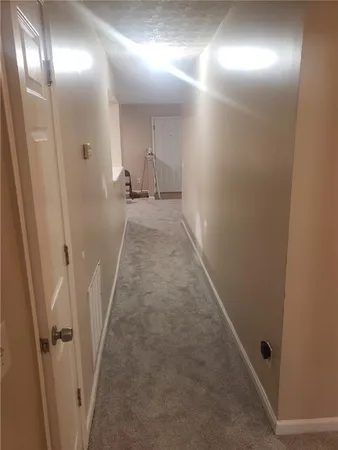 a view of an empty room with closet and a window