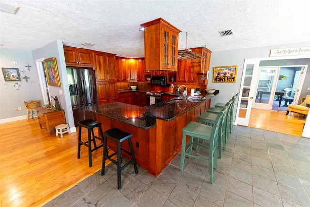 a kitchen with stainless steel appliances granite countertop a stove a sink and a microwave