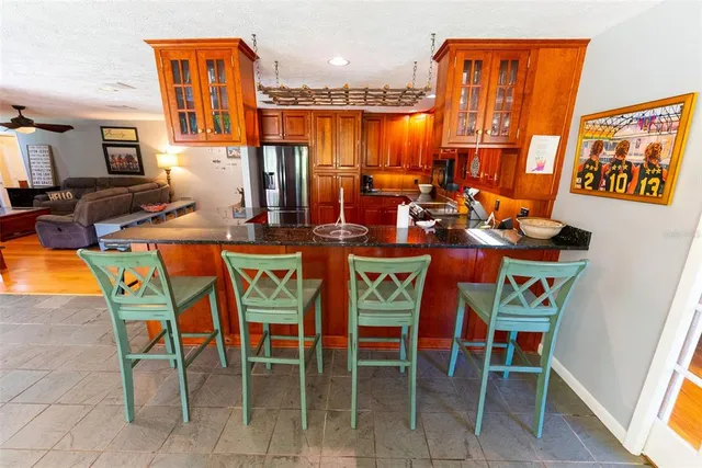 a kitchen with stainless steel appliances granite countertop wooden cabinets a stove a sink and a microwave