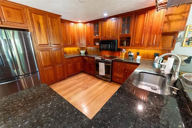 a kitchen with stainless steel appliances granite countertop a refrigerator stove and sink