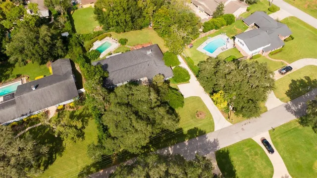 an aerial view of residential house with swimming pool and lawn chairs