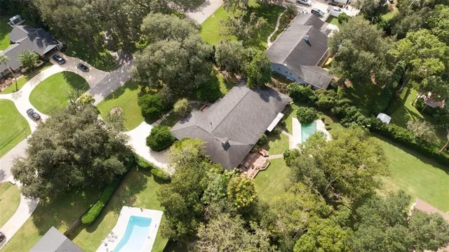 an aerial view of residential house with swimming pool and lawn chairs