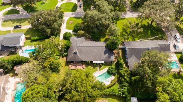 an aerial view of a house with swimming pool and garden