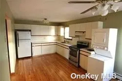 a kitchen with granite countertop a refrigerator stove top oven and sink