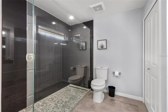 a bathroom with a toilet and a shower