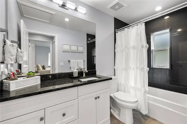 a bathroom with a double vanity sink toilet mirror and bathtub