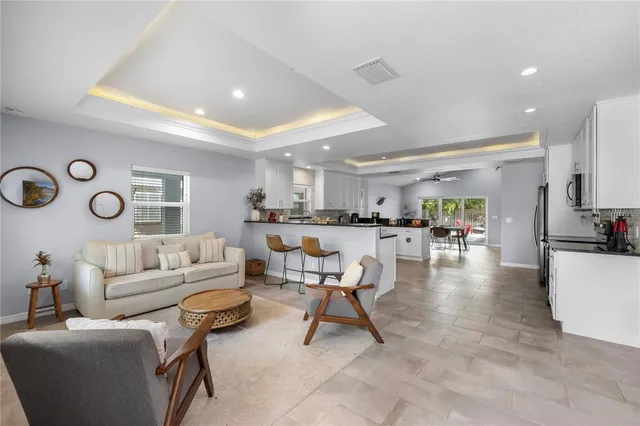 a living room with furniture and view of kitchen