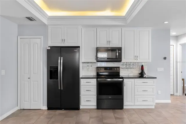 a kitchen with stainless steel appliances granite countertop a refrigerator and a stove