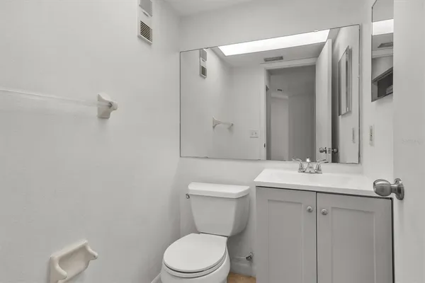 a bathroom with a toilet a sink a mirror and vanity
