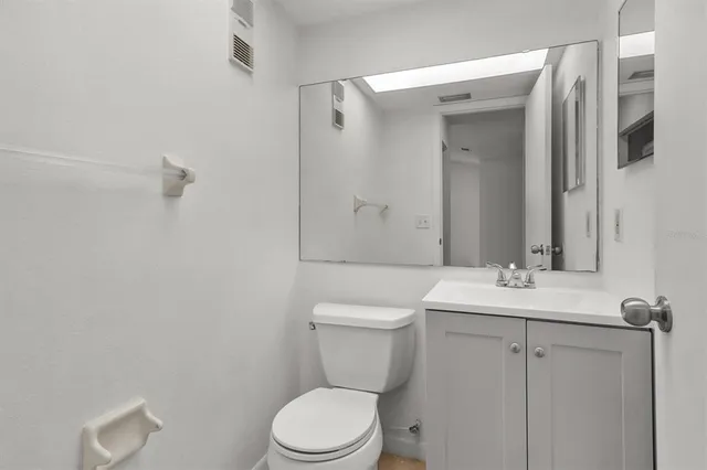 a bathroom with a toilet a sink a mirror and vanity
