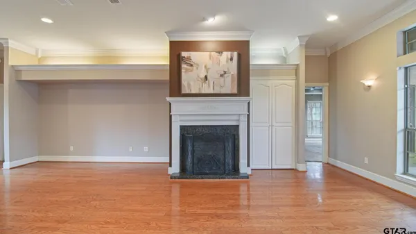 an empty room with wooden floor and a fireplace