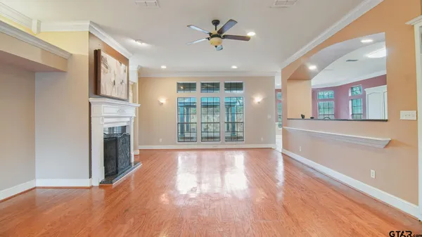 a view of an empty room with a kitchen and a window