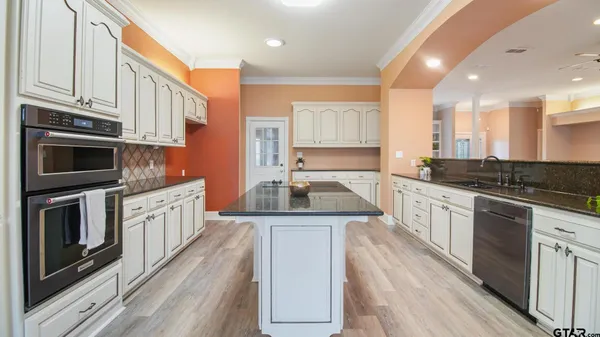 a kitchen with stainless steel appliances granite countertop a stove a sink and a microwave