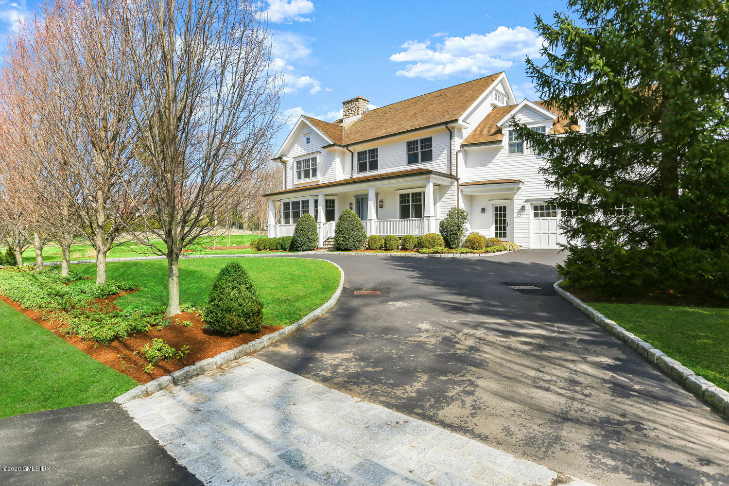 a front view of a house with a yard and trees