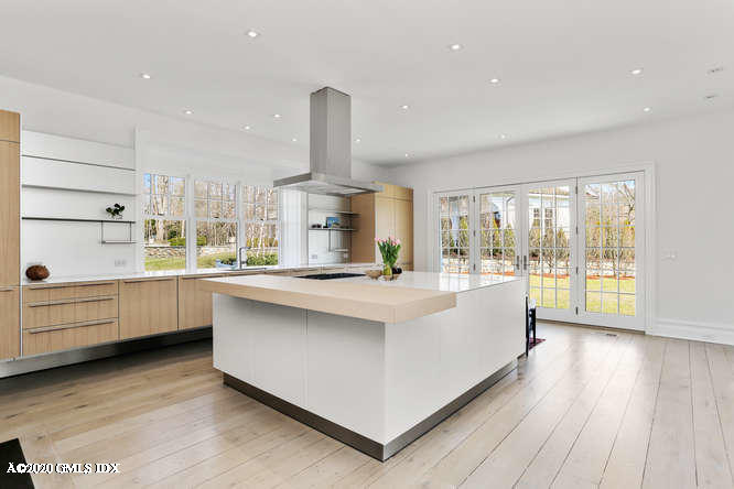 60 Club Road Riverside, CT 06878 - Photo 12 of 44 a large kitchen with kitchen island a sink dishwasher stove and white cabinets with wooden floor