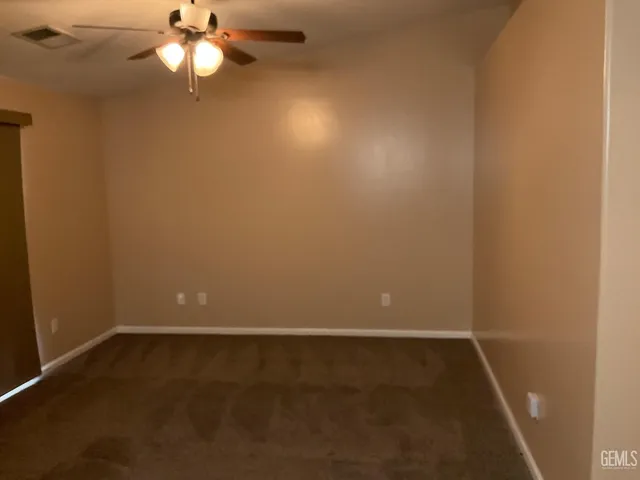 en empty room with a ceiling fan and a window