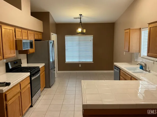 a kitchen with stainless steel appliances a stove a sink and a refrigerator