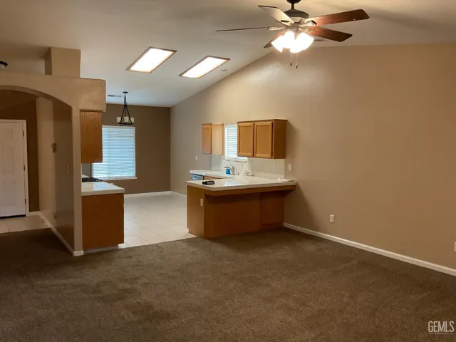 a room with kitchen island a sink wooden floor and a counter top space