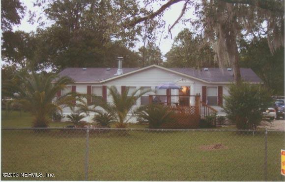 a front view of a house with a yard and lake view