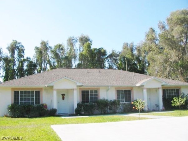 8240-8242 Matanzas Road Fort Myers, FL 33967 - Photo 1 of 8 a front view of a house with garden