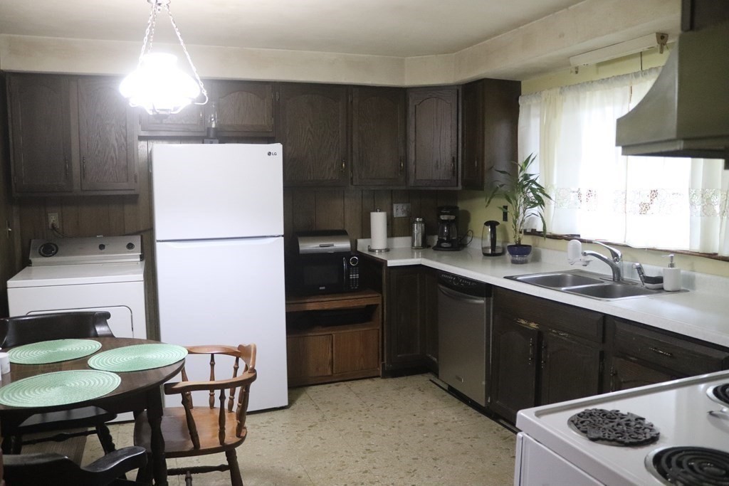 35 Park Road Springfield, MA 01107 - Photo 4 of 23 a kitchen with a sink a stove a refrigerator and chairs