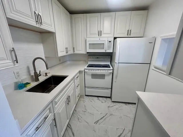a kitchen with a sink a stove a refrigerator and cabinets