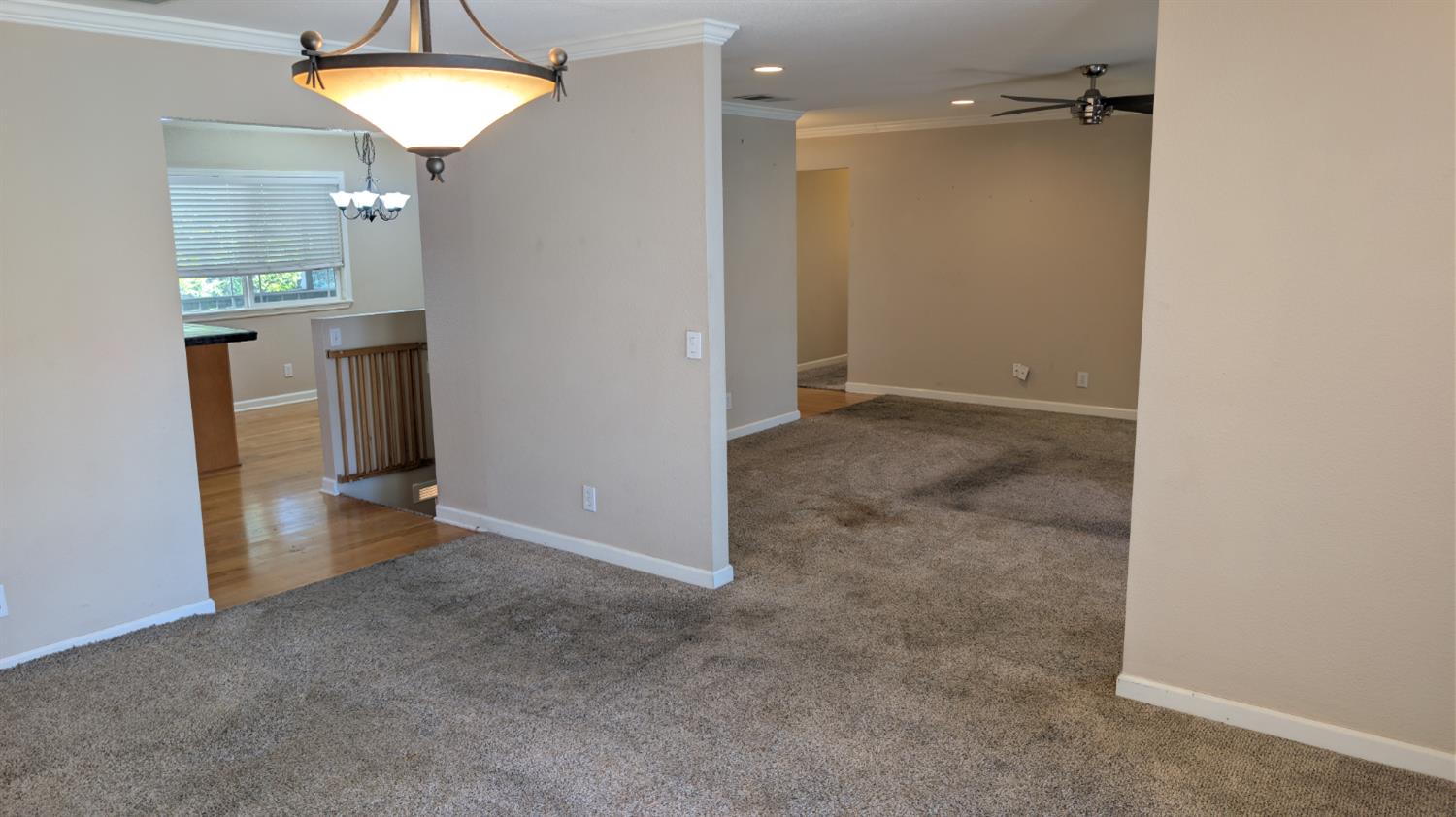 3248 Sudbury Road Cameron Park, CA 95682 - Photo 13 of 41 an empty room with kitchen view and a chandelier fan