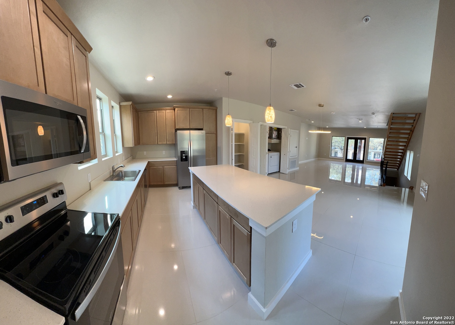 a large kitchen with a large counter top appliances and cabinets
