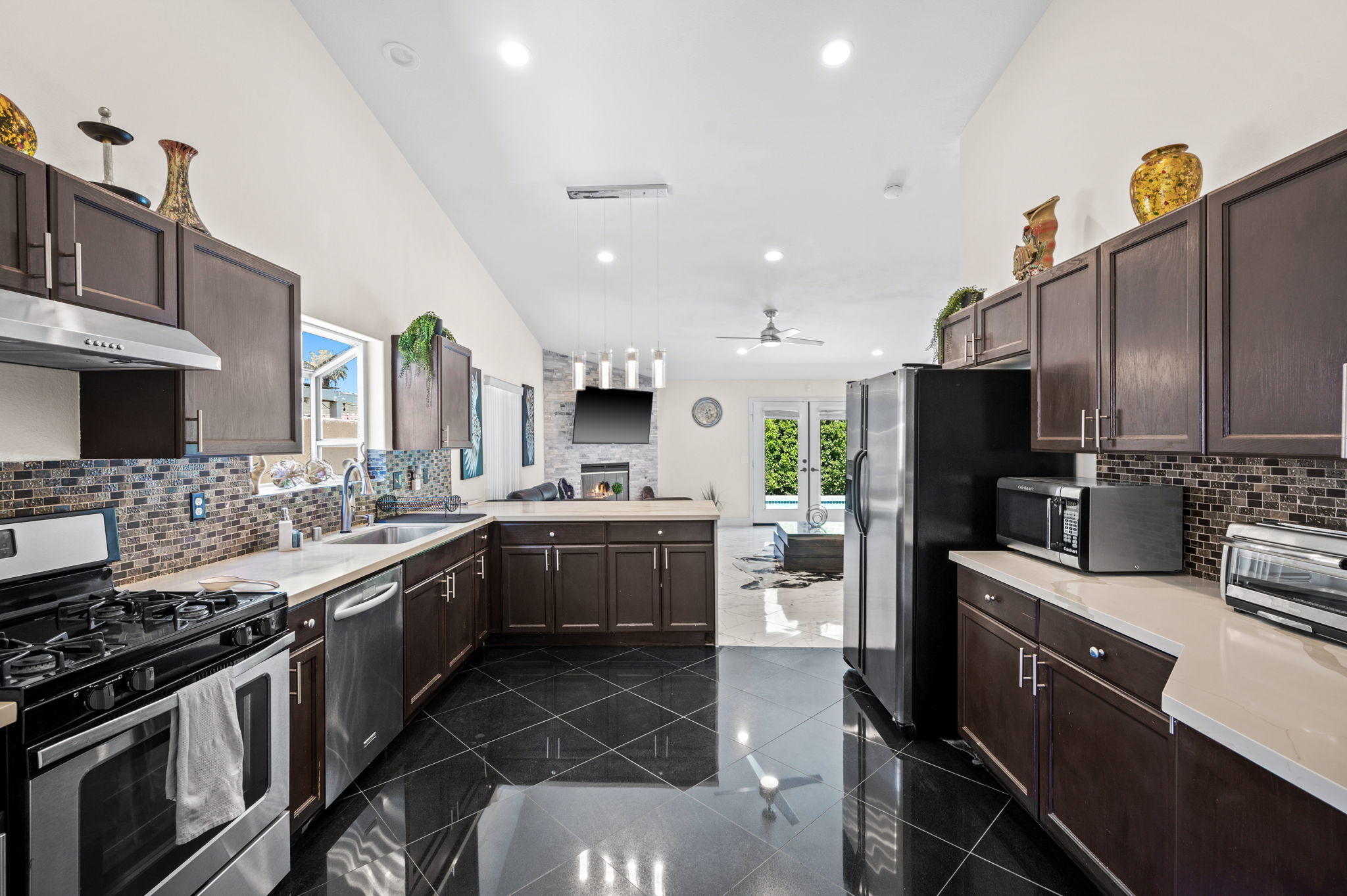 68210 Empalmo Road Cathedral City, CA 92234 - Photo 11 of 34 a kitchen with stainless steel appliances a stove sink and cabinets