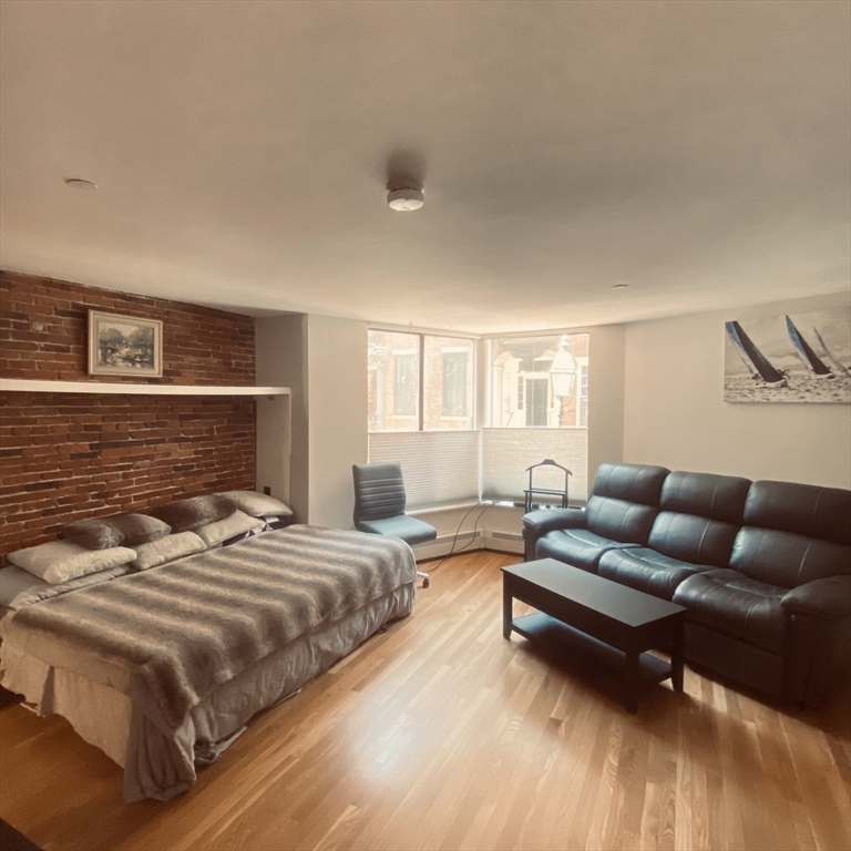 34 Hancock Street, Unit 1D Boston, MA 02114 - Photo 2 of 10 a bedroom with a bed couch and a dresser next to a window