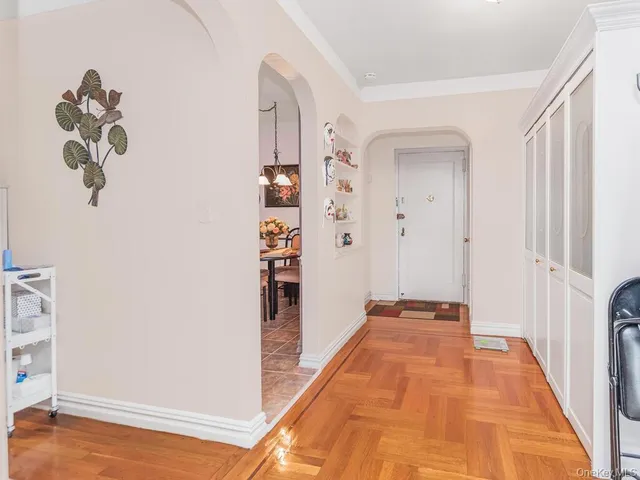 a view of a hallway with wooden floor and closet
